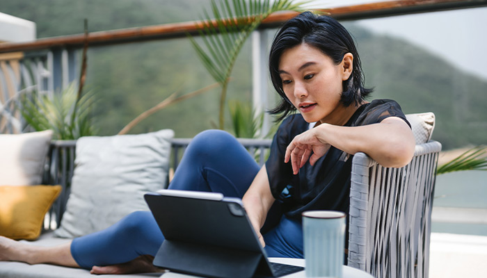 Asian Pacific woman using online banking on her tablet.