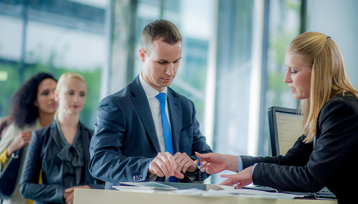 Male customer work with a female banker in a form setting.