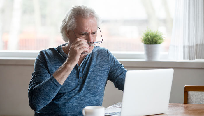 Older gentleman looking concerned at his laptop screen