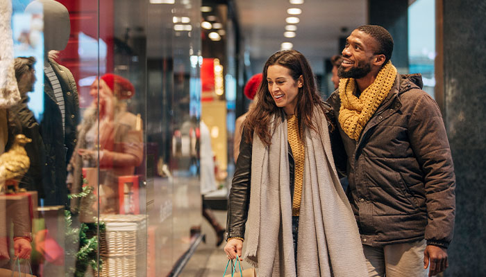 Diverse couple walking through a mall holiday shopping for family and friends.