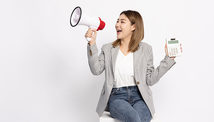 Asian girl speaking into a microphone while holding a calcluator